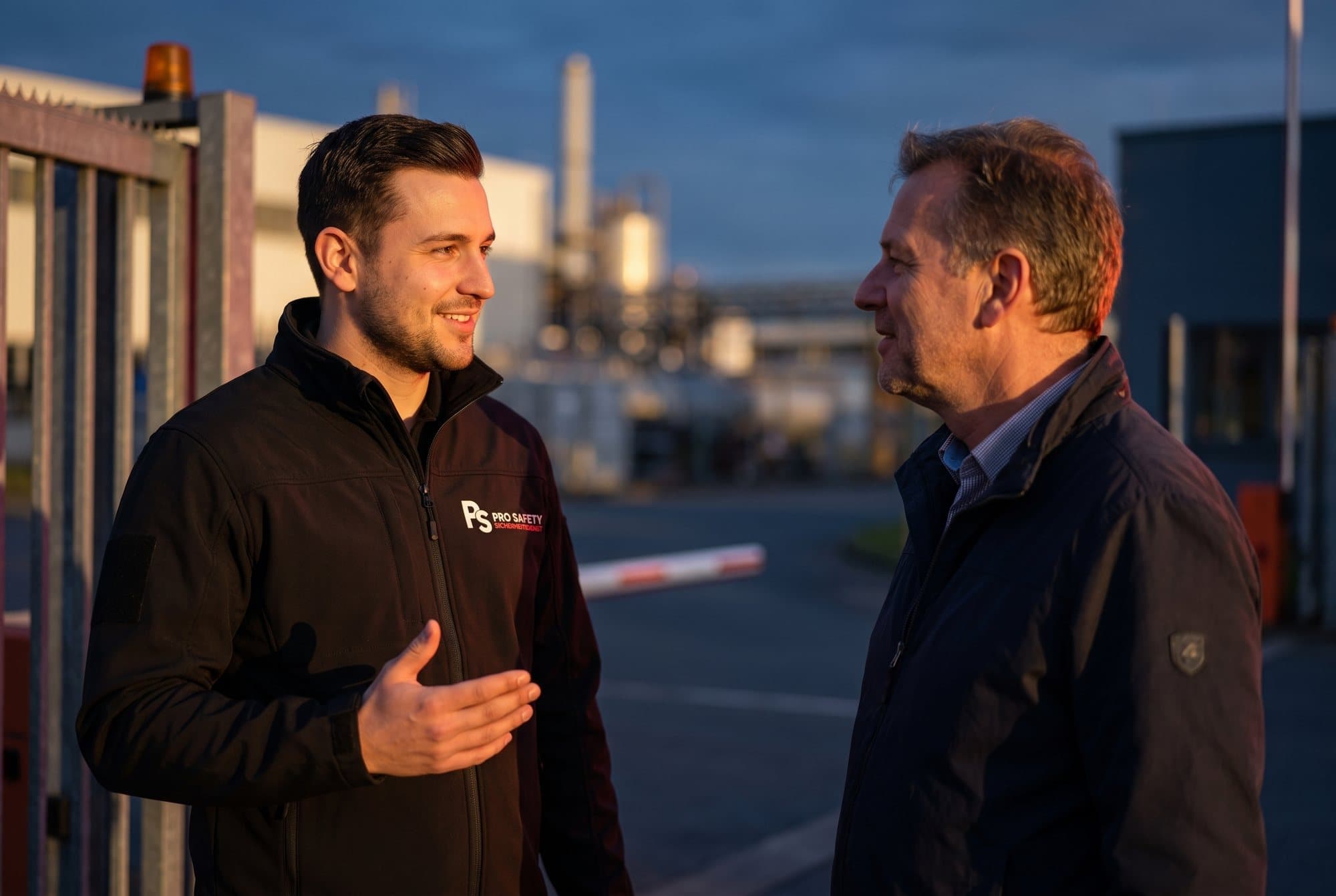 Pro-Safety-Mitarbeiter im freundlichen Gespräch an einer Werkseinfahrt